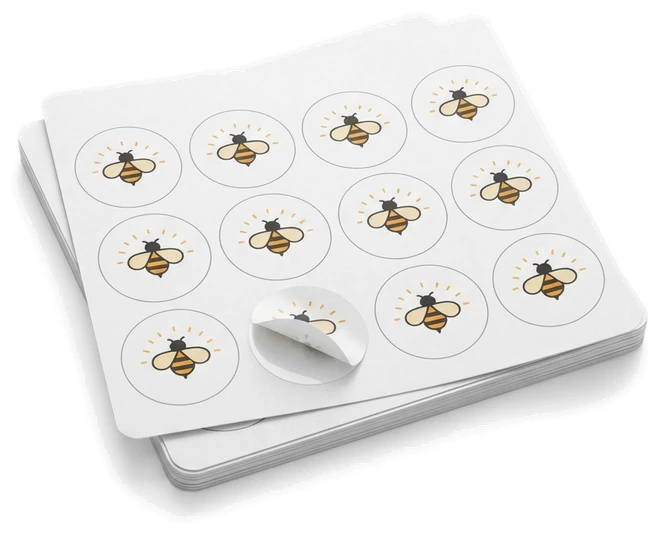 A sticker sheet of identical round honeybee labels, one label half peeled